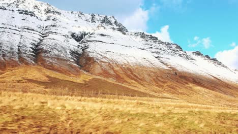Erstaunliche-Aussicht-Vom-Auto-Beim-Vorbeifahren-An-Einem-Schneebedeckten-Berg-In-Island