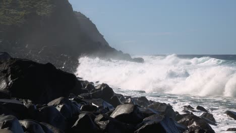 Big-waves-rolling-and-crashing-into-rocky-coast-on-sunny-day