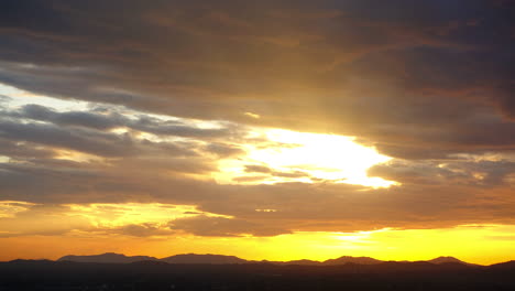 Goldener-Sonnenaufgang-Mit-Sich-Schnell-Bewegenden-Wolken,-Goldene-Wolkenlandschaft