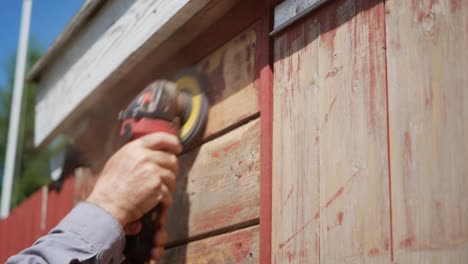 Removing-old-paint-from-wooden-house-by-sanding-machine