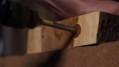 Core-drill-drilling-a-hallow-hole-on-a-wooden-plank-edge,-closeup