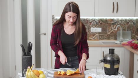 beautiful-girl-slices-oranges-and-makes-juice-in-the-juicer