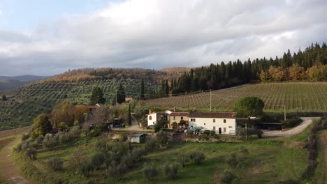 Farmhouse-in-Chianti-vineyards-hills-Tuscany-Italy,-aerial-circle-pan