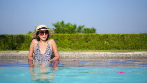 Fashionable-woman-sitting-in-swimming-pool