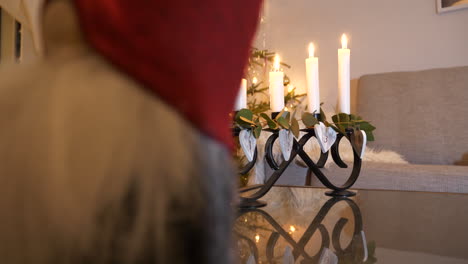 Four-lit-traditional-advent-candles-behind-Santa-Claus-doll,-Reveal-shot