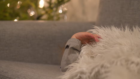 Sleepy-baby-boy-lying-on-sofa-after-Christmas-celebrations-or-New-Years-eve