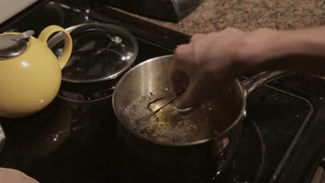 A-Man-Frying-Breaded-Meat-In-A-Boiling-Pot-With-Oil---Close-Up-Shot
