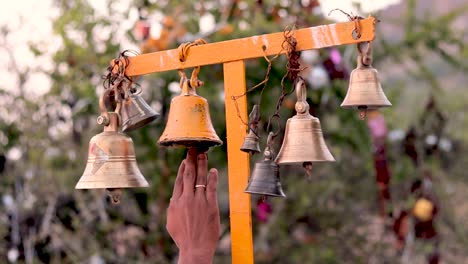 Close-up-of-Hand-Ringing-the-hanged-bell-outside-the-temple