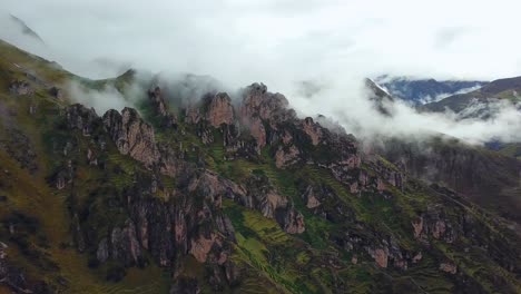 Aéreo,-Pan,-Tiro-De-Drones-Con-Vistas-A-Formaciones-Rocosas,-Nubes-Bajas-Y-Niebla,-En-Las-Montañas-De-Los-Andes,-En-Un-Día-Nublado,-Cerca-De-Cuzco,-En-Perú,-Sudamérica