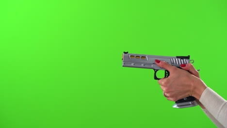 Woman-aiming-large-silver-handgun,-cocking-and-firing-on-green-screen