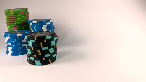 Red-playing-dice-falling-down-next-to-stacks-of-poker-chips,-ISOLATED,-STILL,-SLOMO