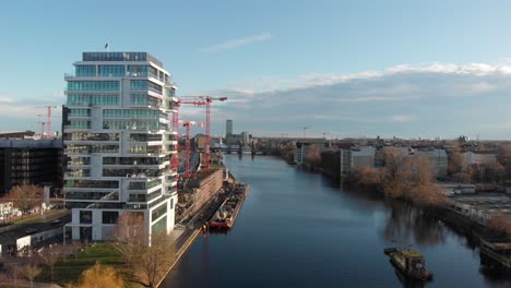 Berlin-wall-from-the-river-Spree-with-a-drone-flying-along-the-river-and-showing-the-Berlin-TV-antenna-made-in-4k-24fps