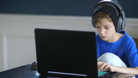 Niño-Jugando-En-Su-Computadora-Portátil-Y-Usando-Auriculares
