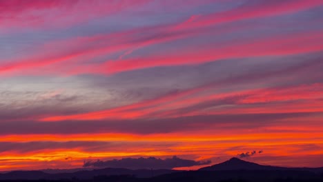 Time-lapse-of-colorful-sunset-clouds-moving-over-Ostrzyca-Proboszczowicka-mountain