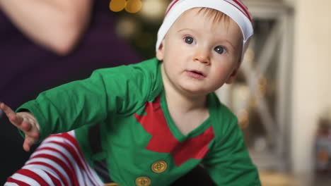 Close-up-of-adorable-baby-with-big-blue-eyes-wearing-elf-costume-for-Christmas-holiday-season