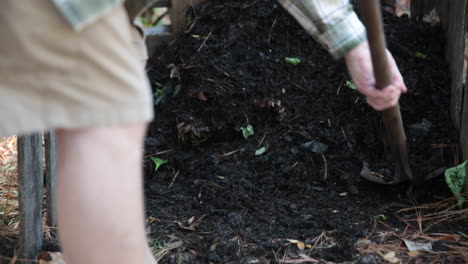 Shoveling-compost-in-a-DIY-pallet-bin