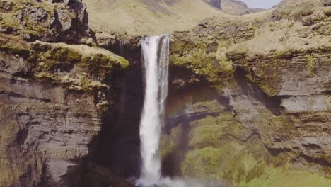 Hidden-Kvernufoss-waterfall-in-Iceland-highlands,-aerial-pull-away-reveal