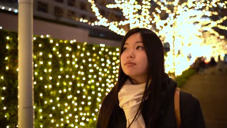 Young-Fair-Skinned-Japanese-Girl-Strolling-Through-Beautifully-Lighted-Pathway-In-Tokyo,-Japan---close-up