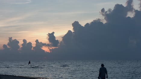 Solitary-man-walking-on-beach-at-twilight