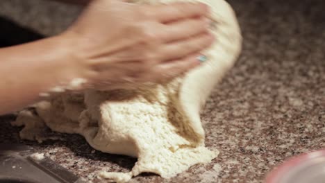woman-kneading-dough-with-her-own-hands-in-a-marble-countertop-in-slow-motion