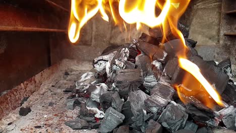 Slow-motion-slide-Barbecue-bbq-coal-charcoals-on-fire-and-burning-with-big-orange-flames-in-slow-motion,-ready-to-grill-and-fry-meat