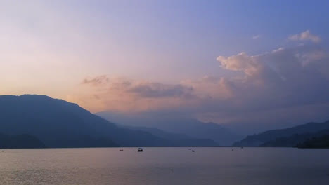 Ein-Zeitraffer-Von-Booten-Auf-Einem-See-Bei-Sonnenuntergang-Mit-Bergen-Im-Hintergrund