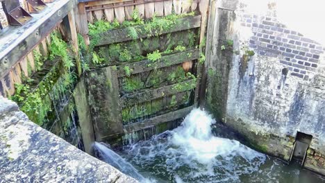 Close-up-view-of-lock-gates-leaking-water-on-a-canal-as-the-water-level-goes-down