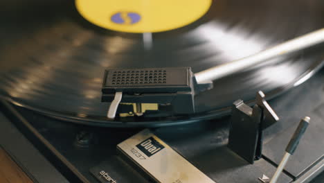 A-male-hand-puts-the-needle-onto-a-vintage-lp-vinyl-record-as-the-record-spins