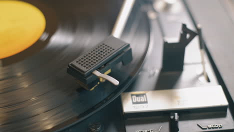 Cinematic-movement-around-a-lp-record-player-needle,-close-up-slide-as-the-record-spins-slowly