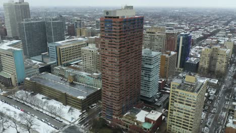 Orbiting-Aerial-Shot-of-Brick-High-Rise-Apartment-Building-on-Cold-Winter-Day