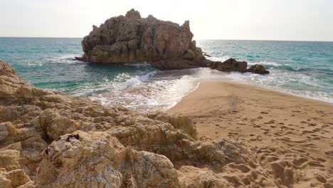 beautiful-mediterranean-sand-beach-,maresme-barcelona,-san-pol-de-mar,-with-rocks-and-calm-sea-and-turquoise-,-costa-brava