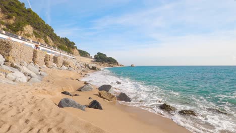 beautiful-mediterranean-sand-beach-,maresme-barcelona,-san-pol-de-mar,-with-rocks-and-calm-sea-and-turquoise-,-costa-brava