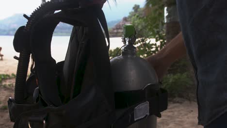 Hombre-En-Una-Playa-Exótica-Arreglando-Bcd-En-Una-Botella-De-Gas,-Islas-Comoras,-Moheli