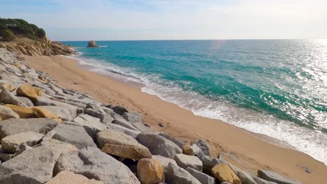 beautiful-mediterranean-sand-beach-,maresme-barcelona,-san-pol-de-mar,-with-rocks-and-calm-sea-and-turquoise