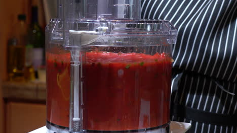 Cook-turns-on-huge-blender-to-mix-tomato-sauce