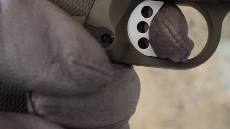 Close-up-of-a-gloved-hand-pulling-the-trigger-of-a-gun