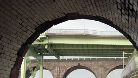 Alte-Industrielle-Bögen-Blick-Auf-Runcorn-Silver-Jubilee-Bridge---Backsteinbögen-Bahnübergang