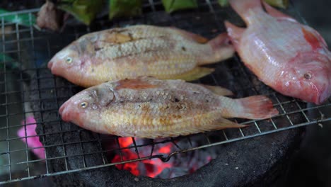 Whole-Exotic-fish-is-being-grilled-on-the-metal-grid-at-the-street-near-a-restaurant-in-Taipei