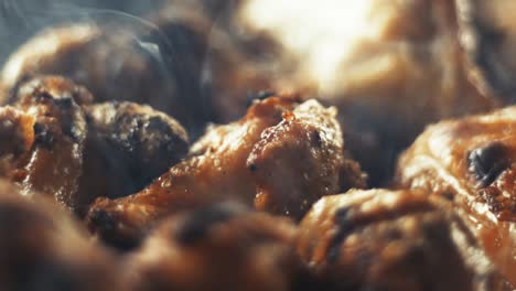 Slow-motion-close-up-shot-of-chicken-wings-and-smoke-from-the-charcoal-grill