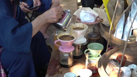 Brewing-a-homemade-cup-of-coffee-in-the-street-market-Chiang-Mai,-Thailand