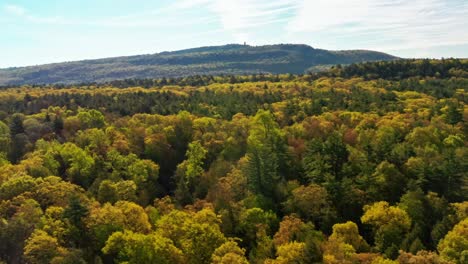 Panning-right-to-left-over-treetops-in-upstate-New-York,-autumn-colors