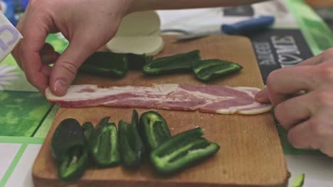 Stuffing-jalapeno-peppers-with-mozzarella-cheese-and-wrapping-them-into-long-slices-of-bacon
