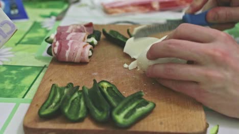 Cutting-mozzarella-cheese-before-preparing-stuffed-jalapeno-peppers-for-baking