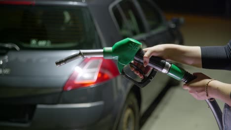 Person-holding-a-green-unleaded-fuel-handle-which-is-out-of-service,-because-there-is-petrol-shortage