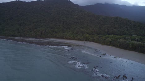 Sandy-Shore-And-Lush-Vegetation-In-Daintree-National-Park-On-A-Cloudy-Day-In-Far-North-Queensland,-Australia---aerial-drone-shot