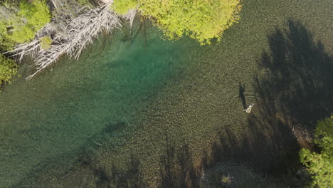 Incredible-top-down-aerial-view-of-a-man-fishing-in-a-river-near-Arroyo-Verde,-Argentina
