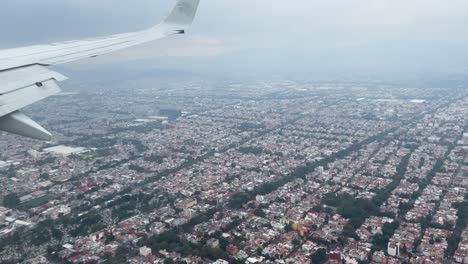 shot-from-the-window-of-the-plane-during-the-landing-over-the-areas-surrounding-the-city-of-mexico