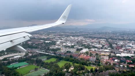 shot-from-the-airplane-window-during-landing-over-the-sports-fields-of-mexico-city