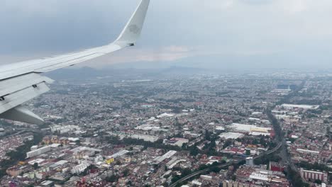 shot-from-the-airplane-window-during-landing-over-the-industrial-zones-of-mexico-city