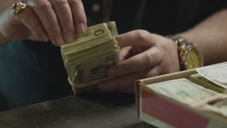 A-mafioso-man-counting-a-stack-of-cash